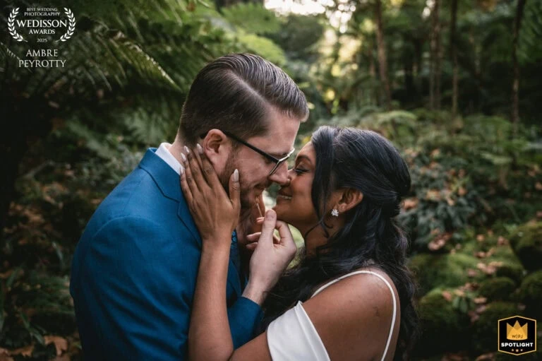 Close-up of a couple sharing a tender moment in a lush forest setting.