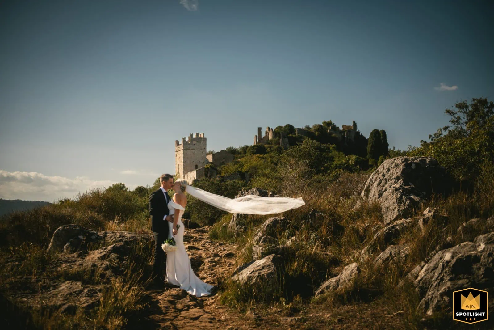 Elopement of a bride and groom in a picturesque outdoor setting with a historic castle in the backgr.