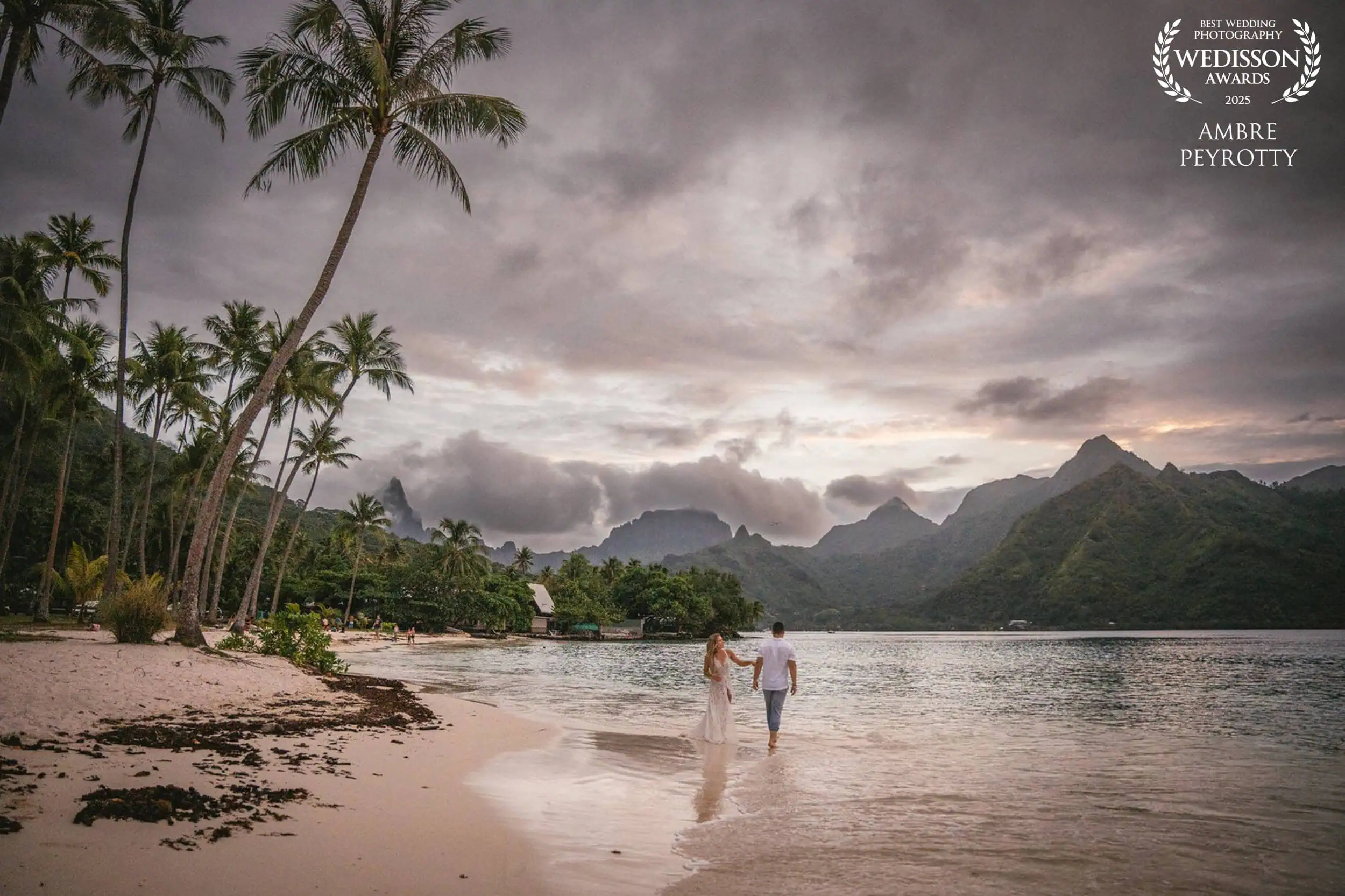Elopement on a tropical beach in French Polynesia with couple walking along the shoreline.