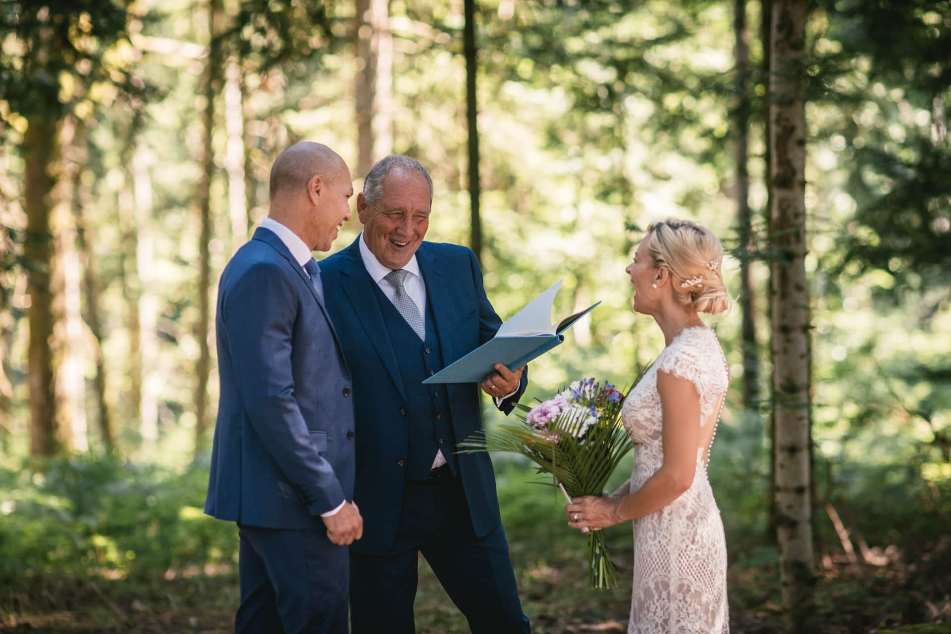 Celebrant showing his book to the bride and groom during their elopement ceremony in Central France
