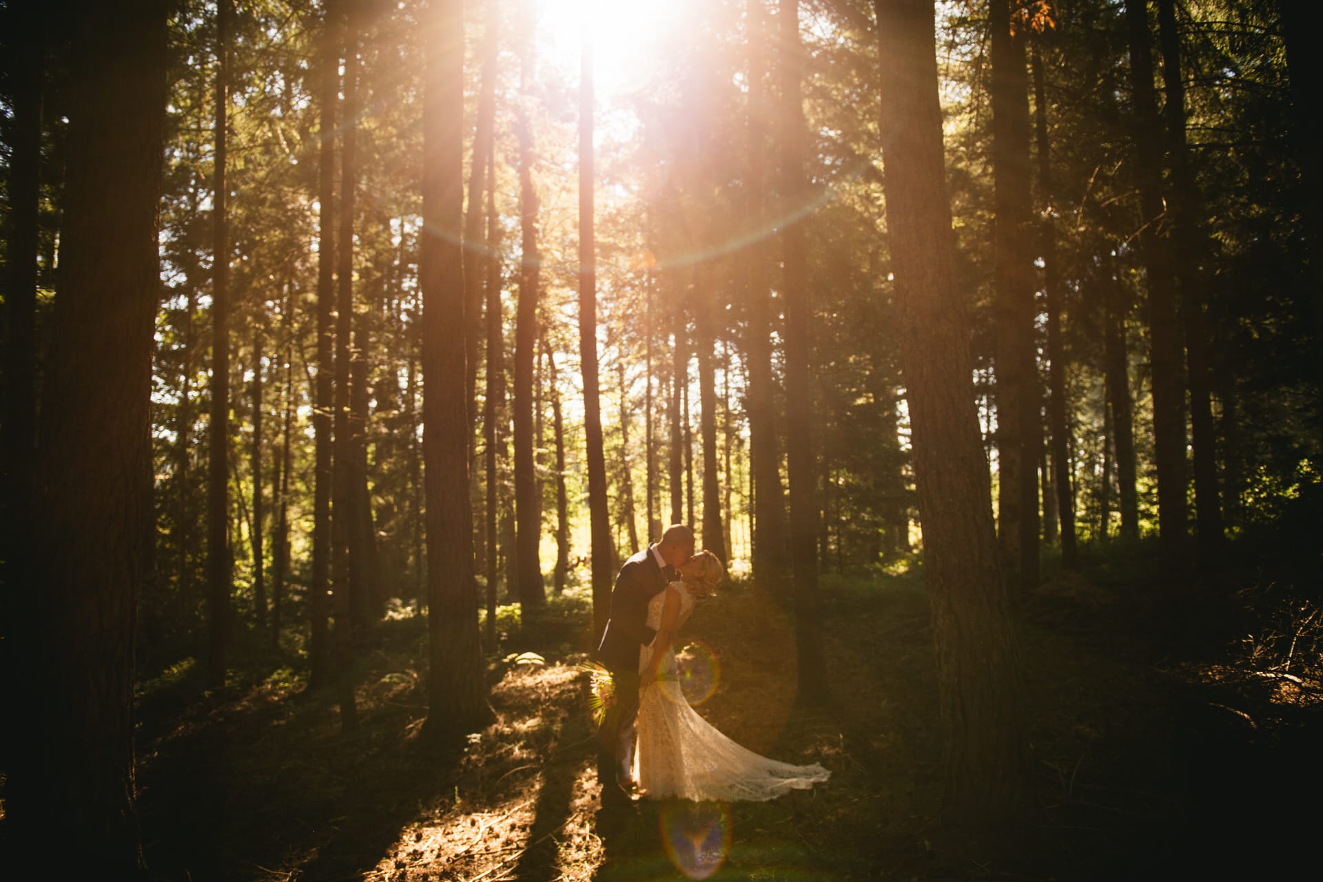 Bride and groom posing at sunset in a central France forest after their elopement ceremony