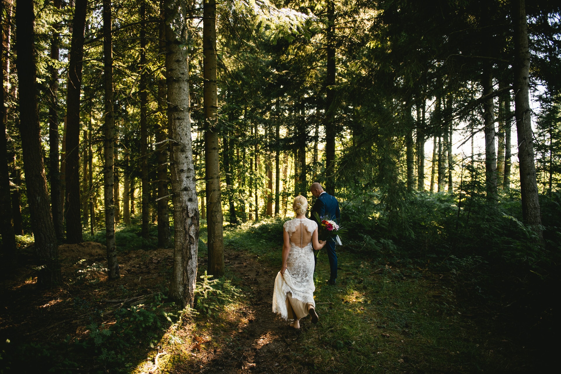 Bride and groom walking in the forest after their elopement ceremony in Central France