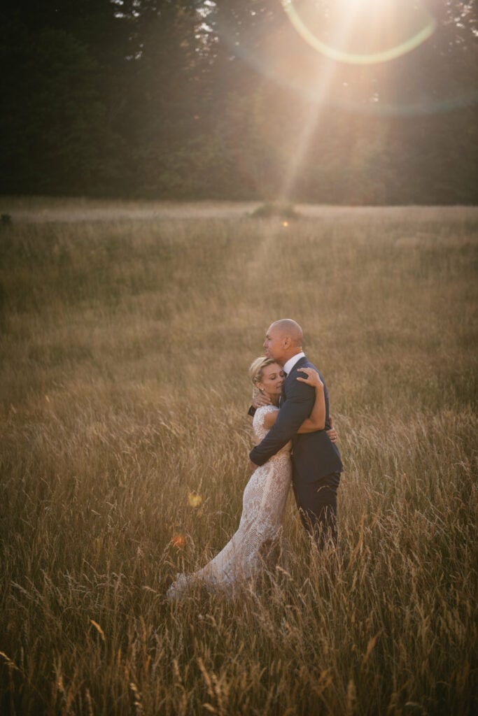 Bride and groom hugging in a field at sunset after their elopement ceremony in Central France