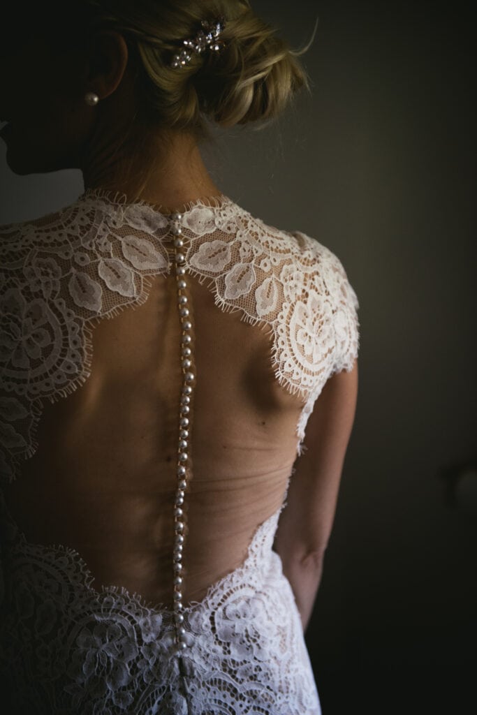 Back of a lace dress with delicate tulle, closed with pearl buttons, perfect for an elopement in Central France