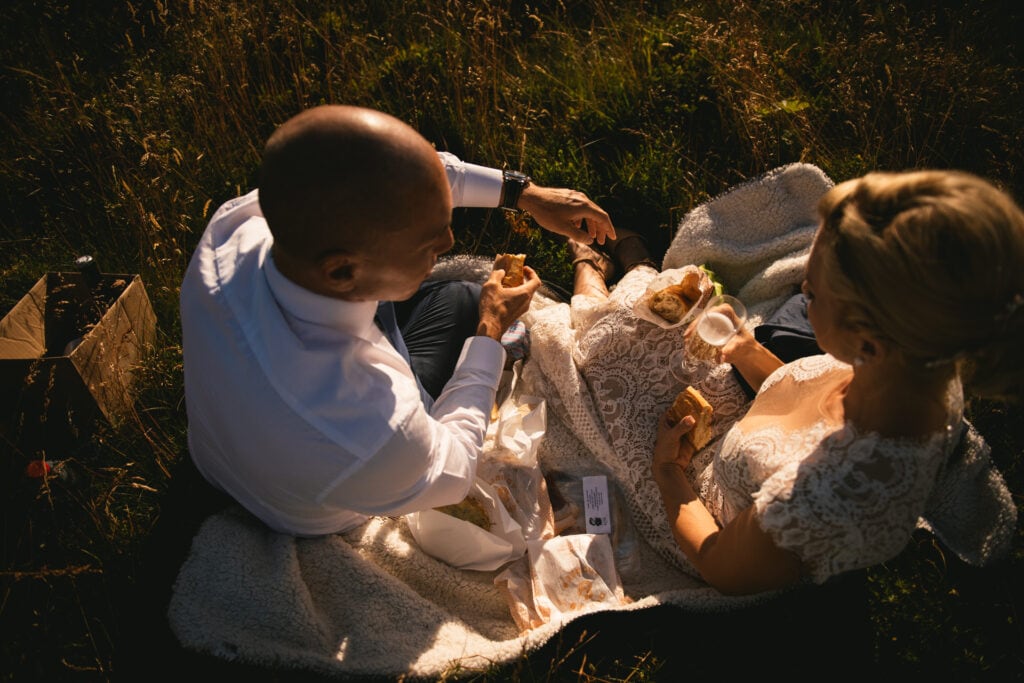 Detail of a picnic elopement with local cheeses and cold cuts in a field in Central France