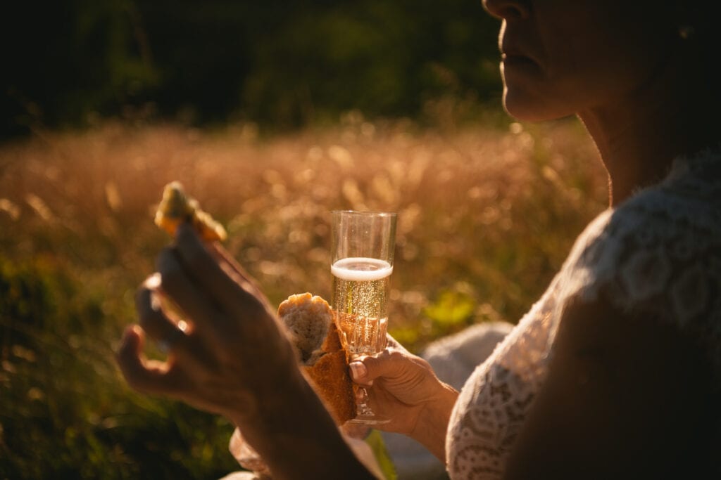 Detail of a glass of champagne at sunset in a field