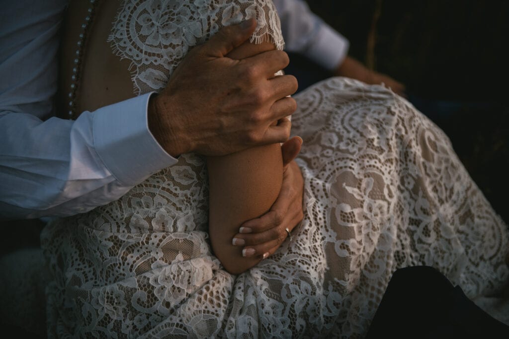 Groom holding his bride's arm in a closeup shot