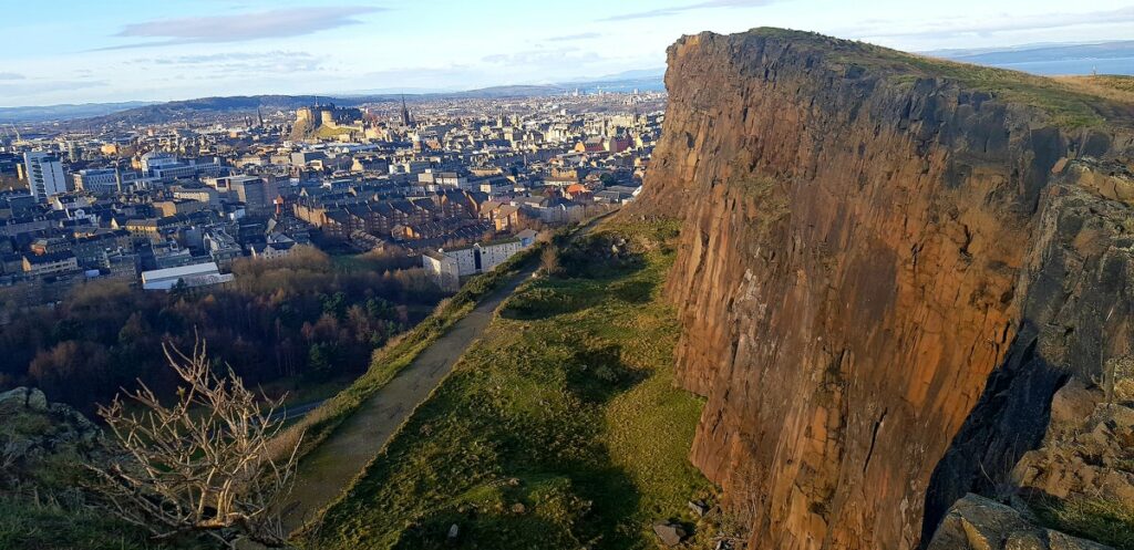 Salisbury crag viewed from a drone, pverlooking the city of Edinburgh, one of the most beautiful places to elope in Edinburgh