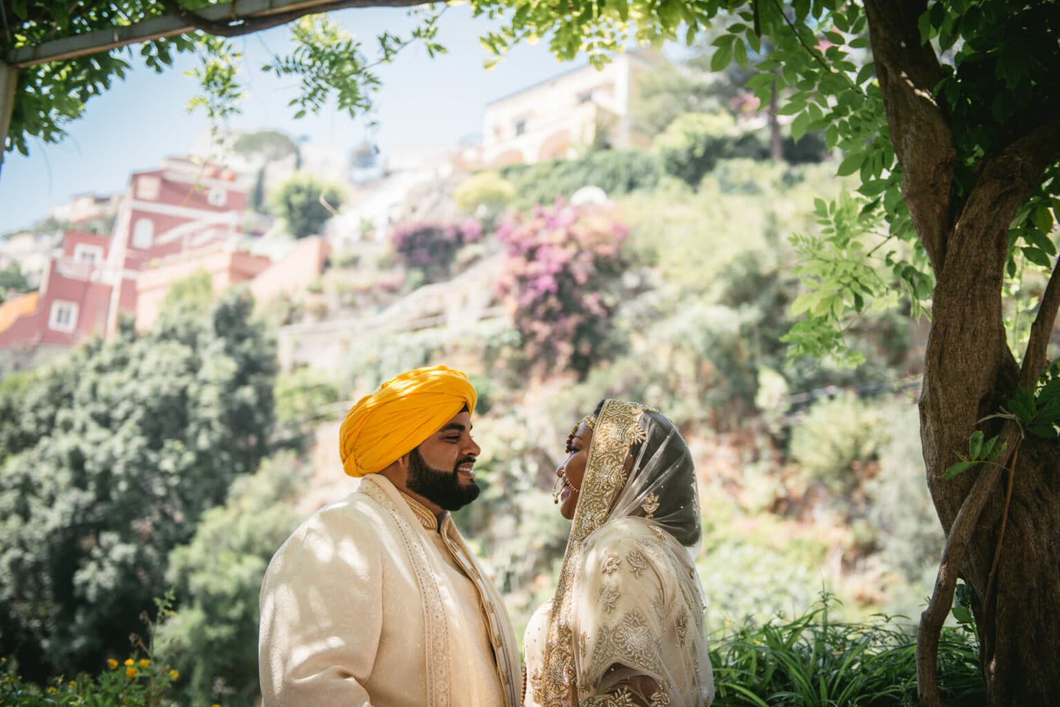 Couple in their traditional Sikh wedding outfits posing in front of flowers during their elopement on the Amalfi Coast