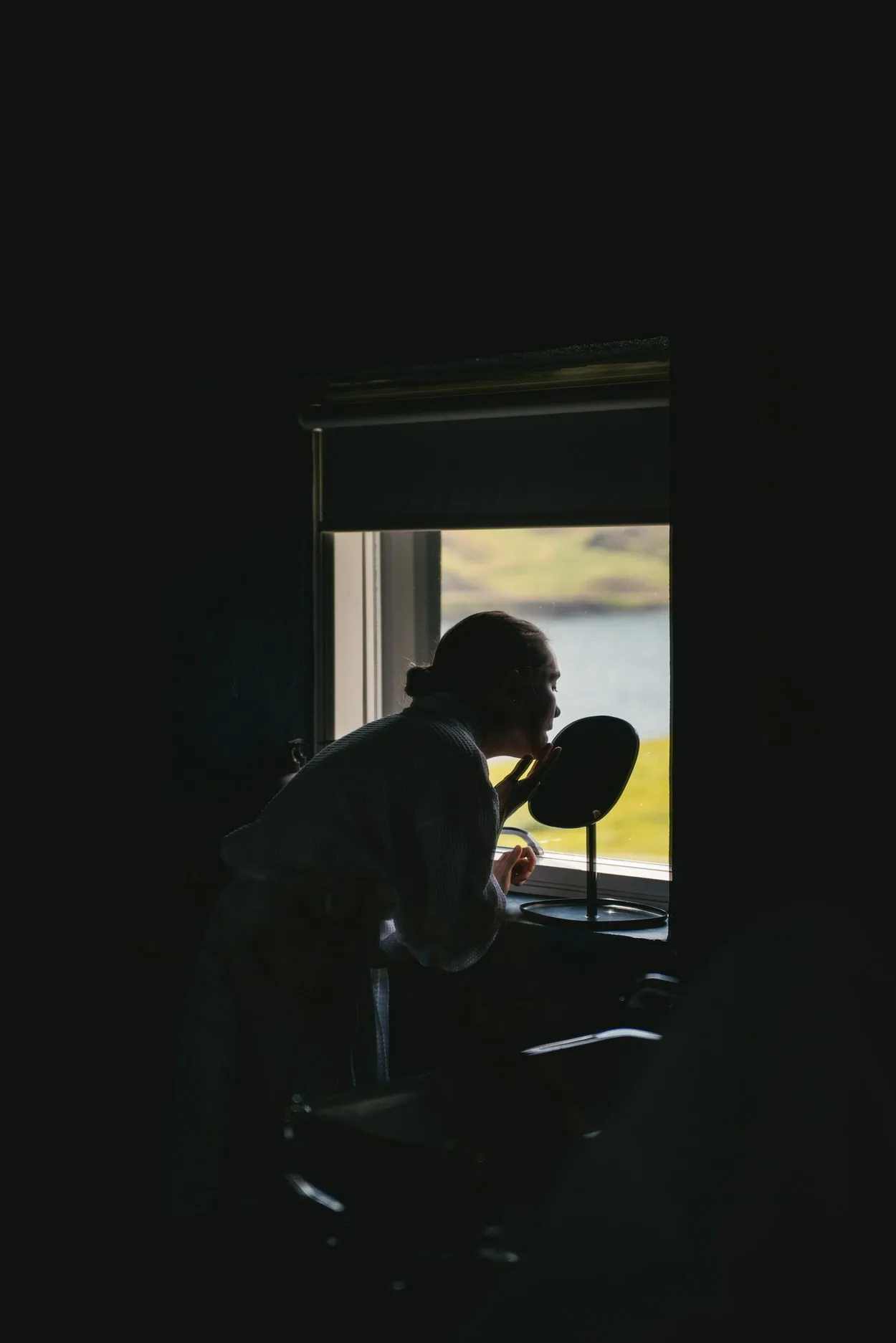 Bride putting makeup on in her cottage in Iceland