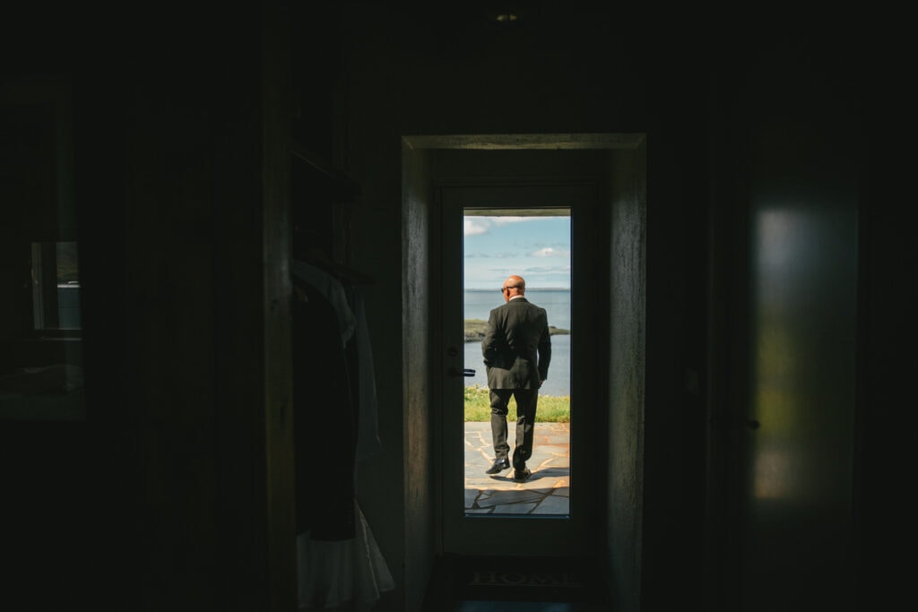Father of the bride waiting patiently outside their cottage in Iceland until they are ready for the ceremony