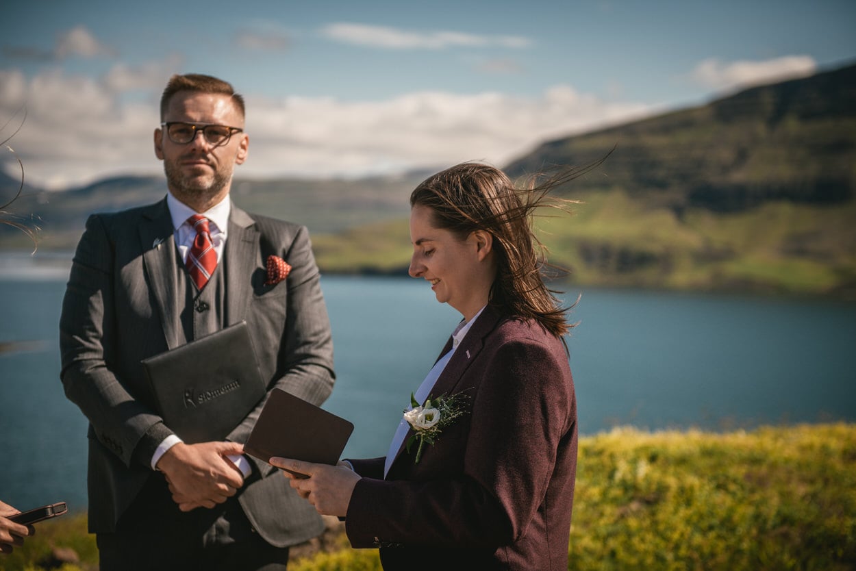 Bride reading her vows during her elopement in Iceland with the wind in her hair