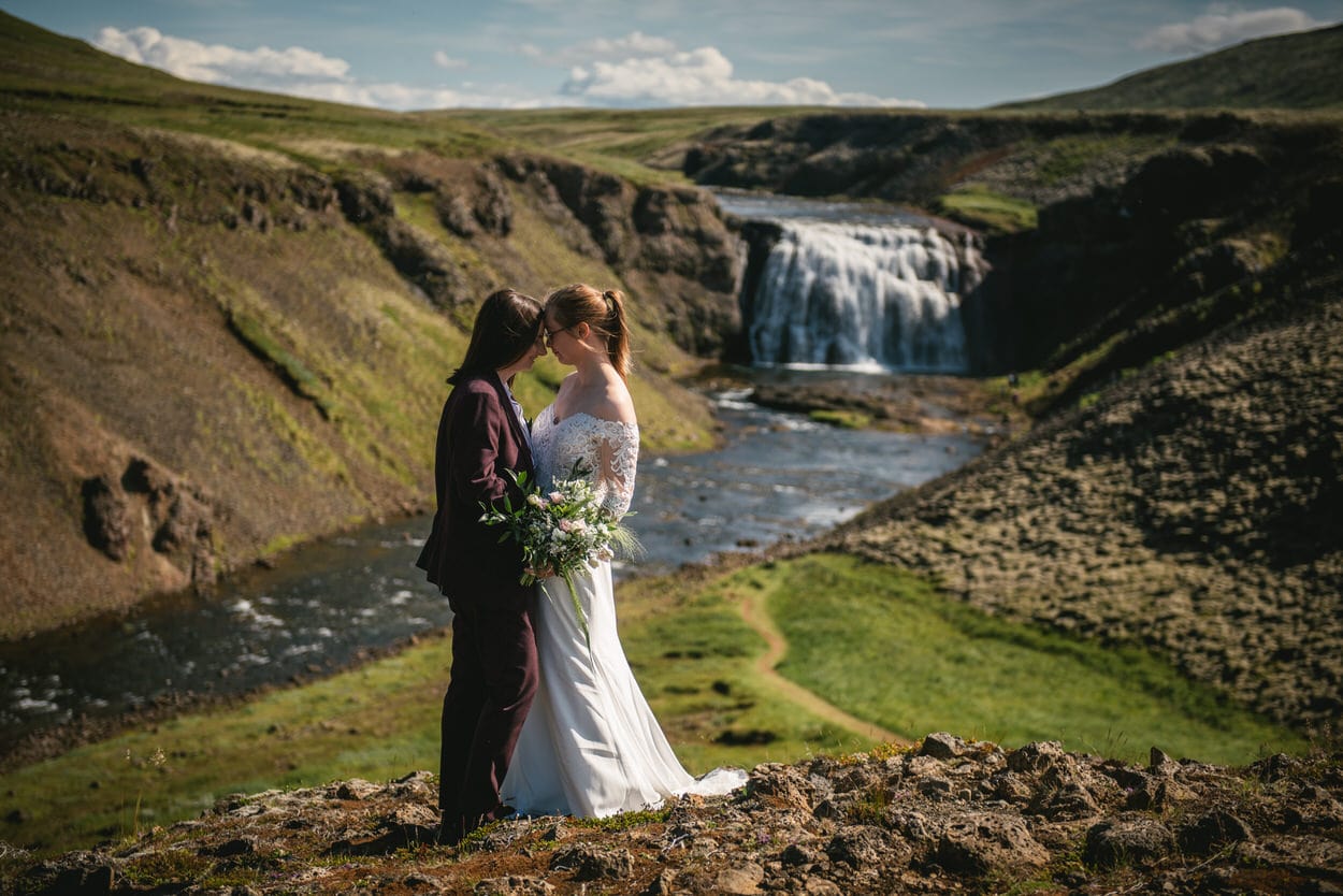 Couple posing in front of Thorufoss during their elopement in Iceland