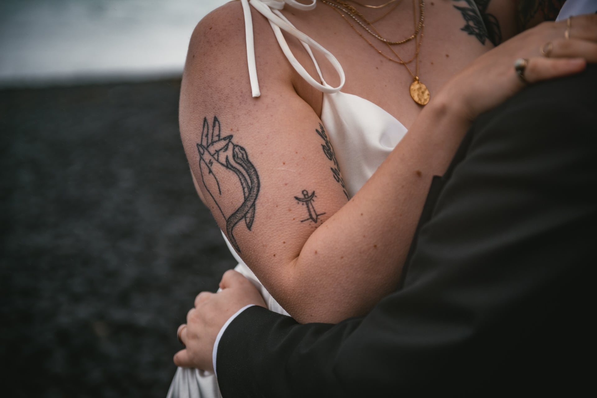 Details of the bride's arm with some old school tattoos