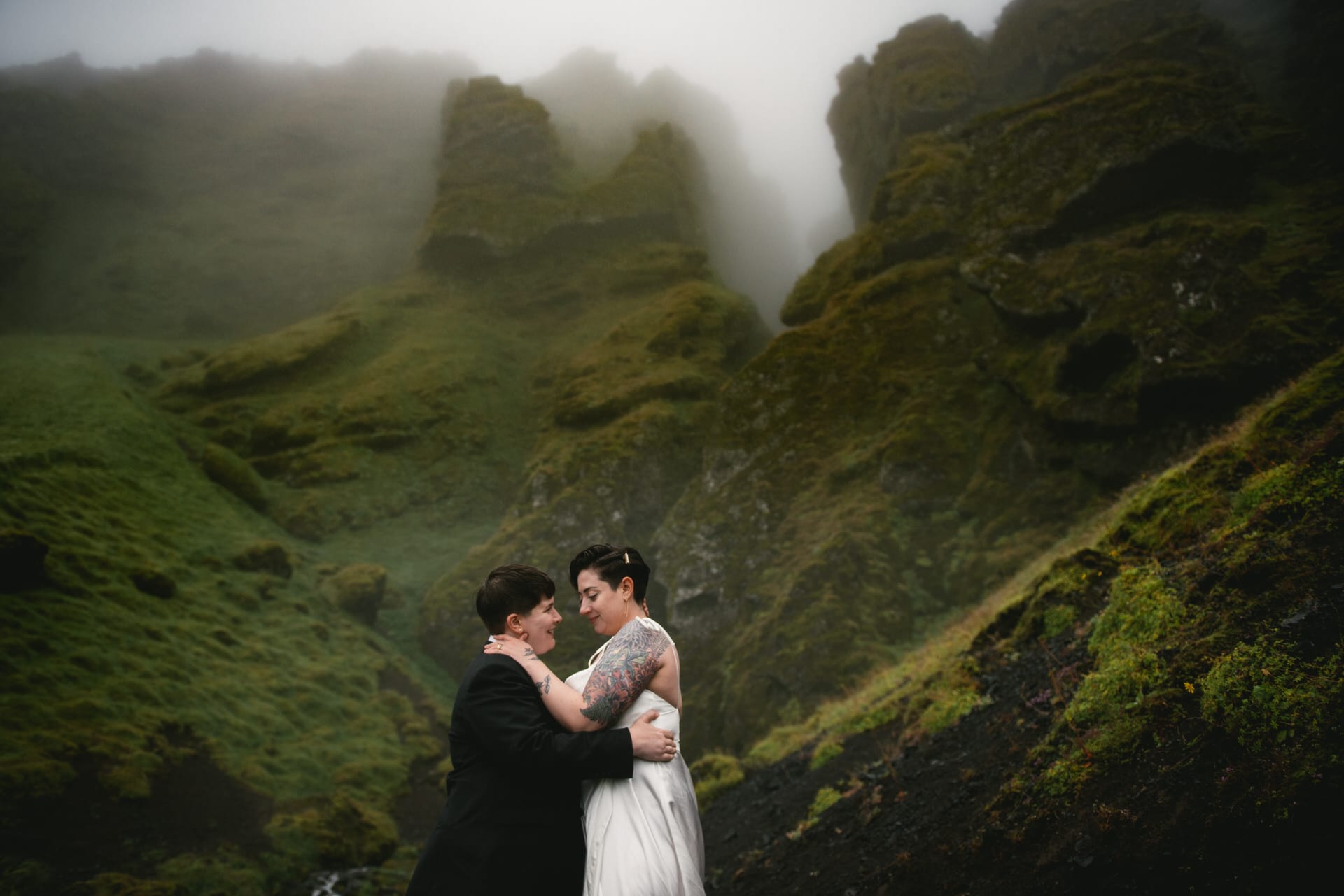 Same-sex couple posing in front of the Raudhfeldsgja gorge on their elopement day in Iceland
