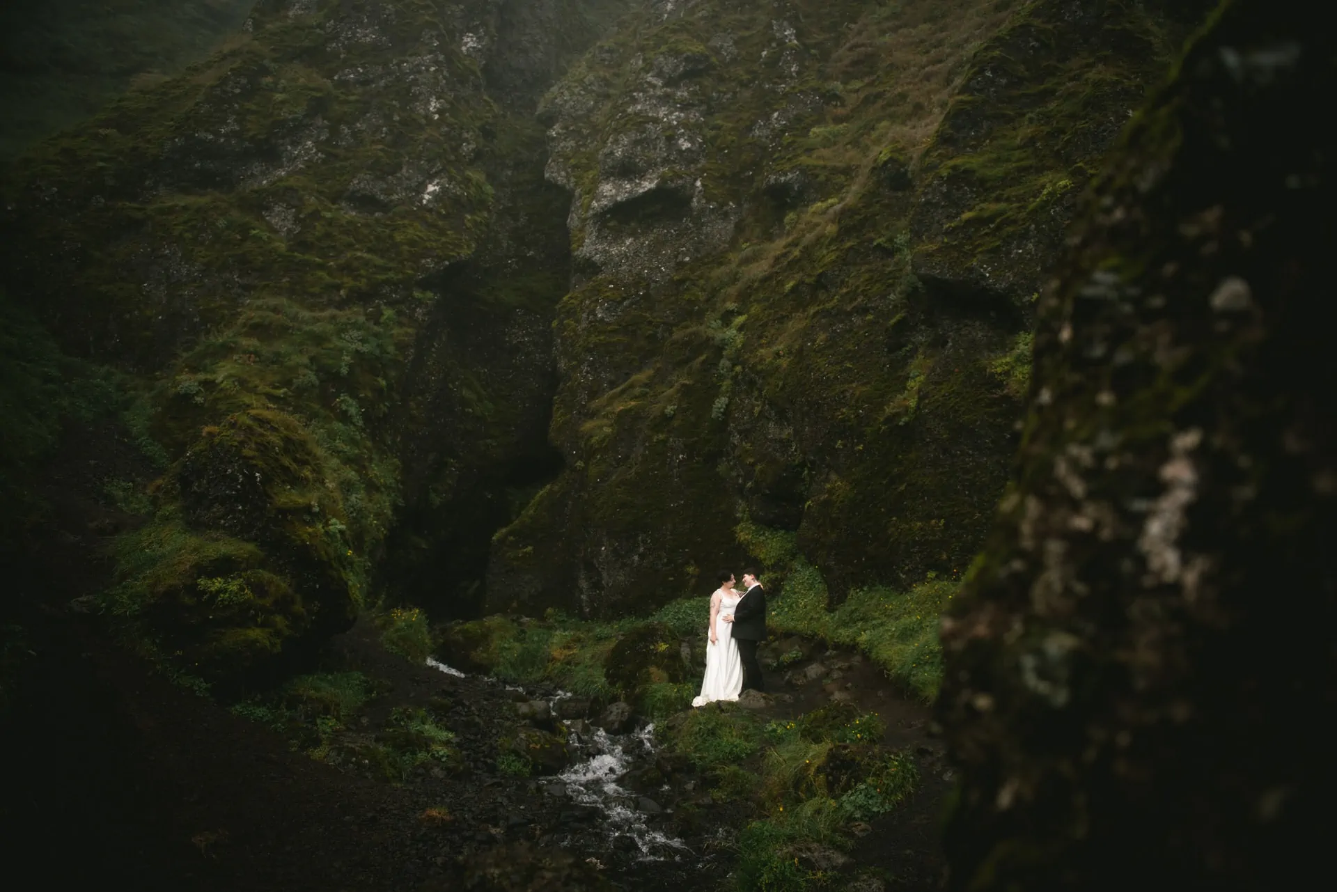 Same-sex couple posing in front of the Raudhfeldsgja gorge on their elopement day in Iceland