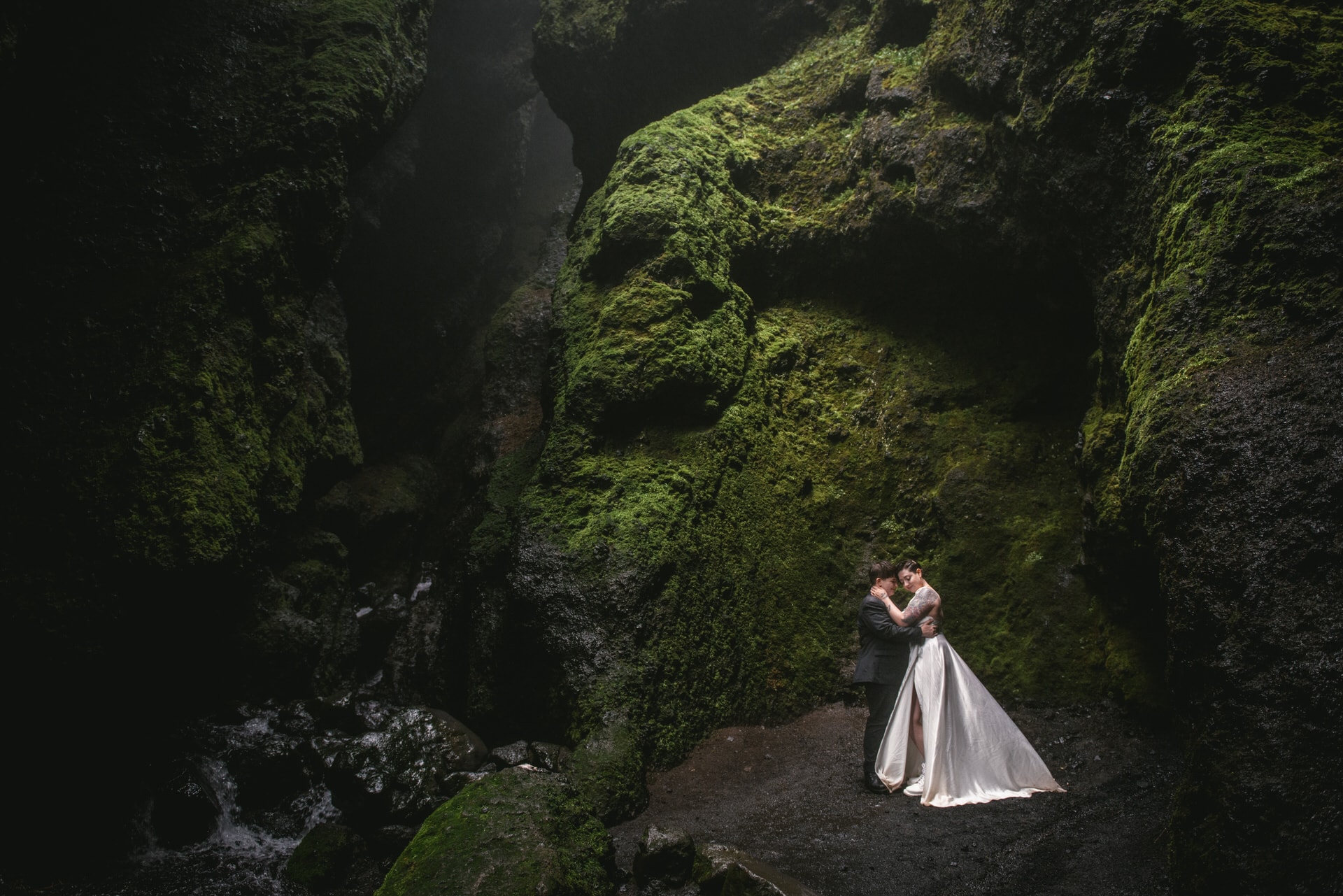 Same-sex couple posing inside the Raudhfeldsgja gorge on their elopement day in Iceland