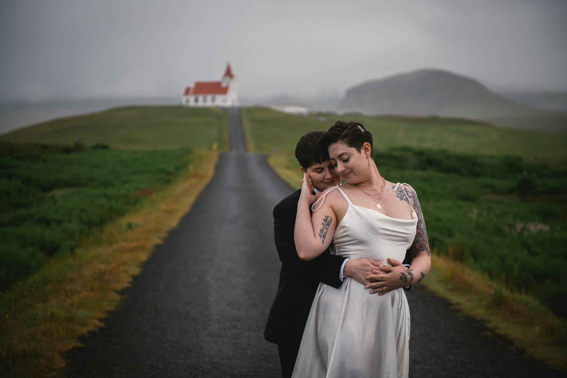 Same-sex couple in front of an icelandic church on their elopement day
