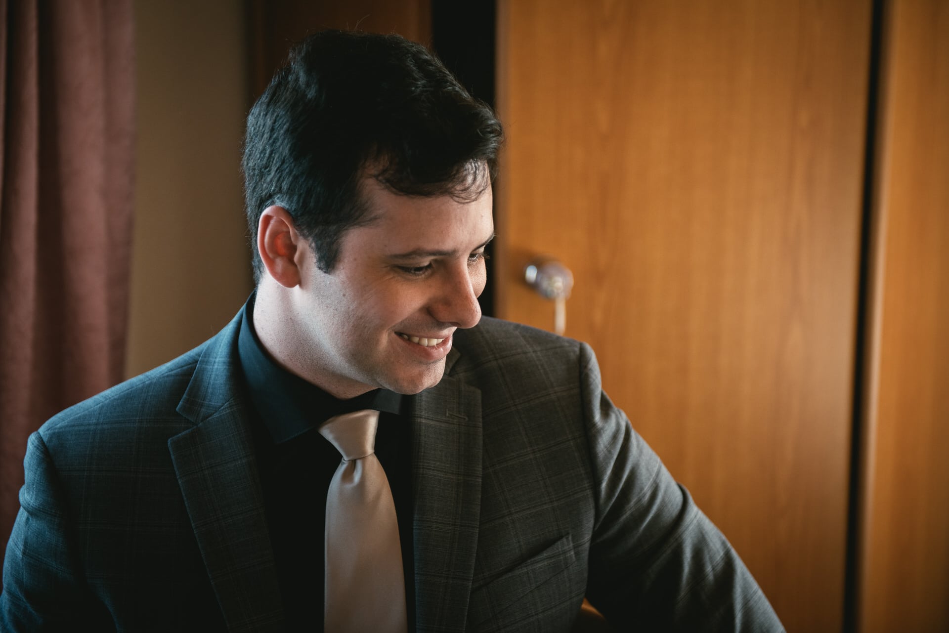 Groom smiling as he gets ready on his elopement day in Switzerland