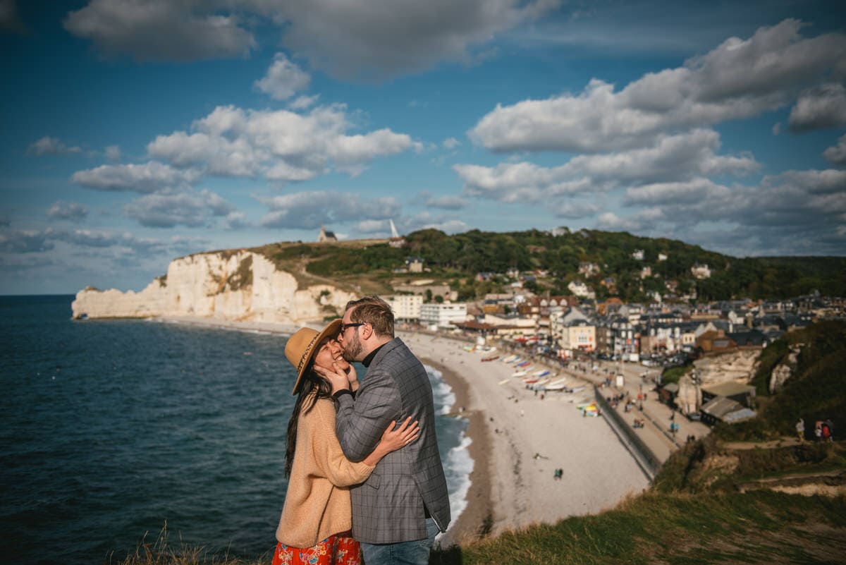 Couple kissing in front on Etretat town before their elopement in Normandy