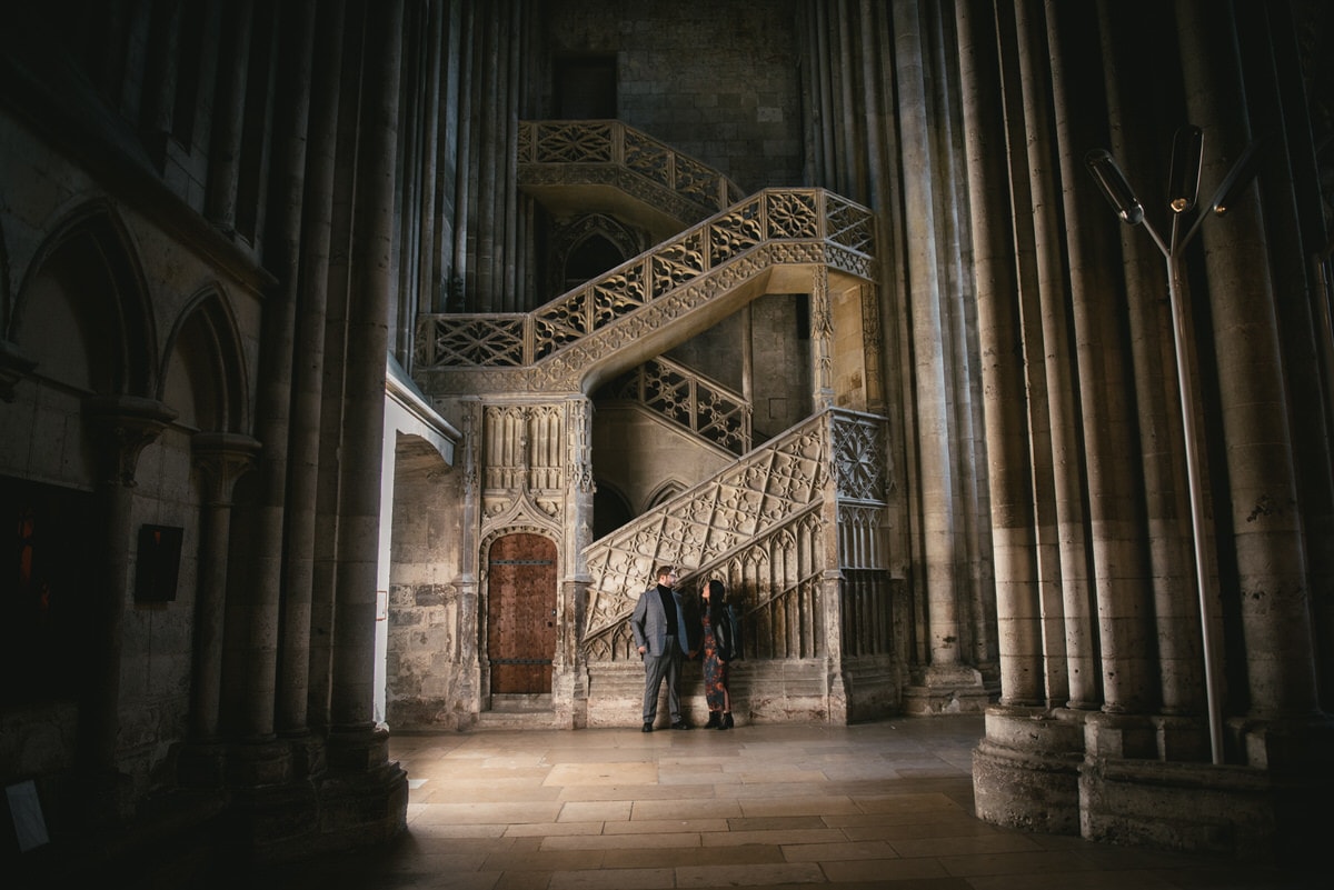 Couple standing in the Rouen cathedral before their elopement in Normandy