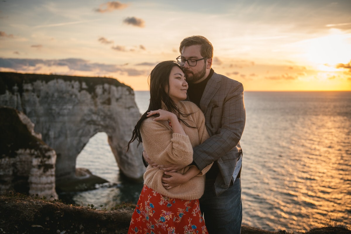 Couple hugging on top of the Etretat cliffs Couple hugging with the Etretat cliffs in the background before their elopement in Normandy