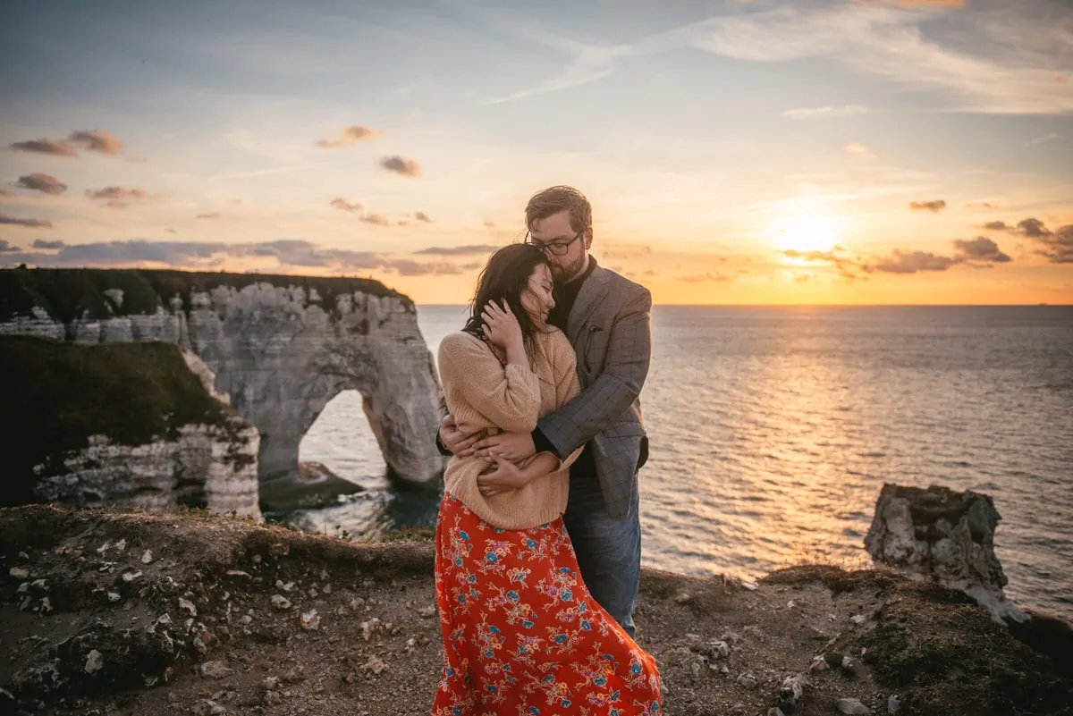 Couple hugging on top of the Etretat cliffs Couple hugging with the Etretat cliffs in the background before their elopement in Normandy