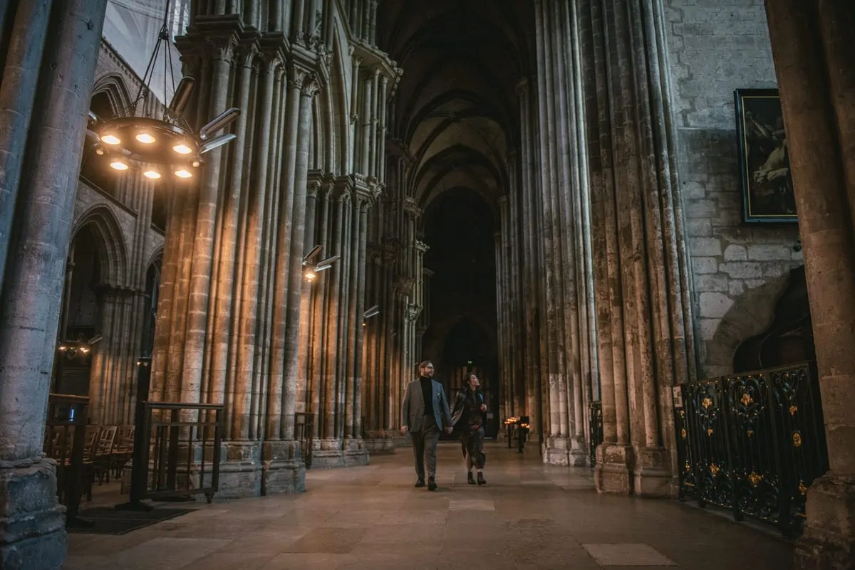 Couple standing in the Rouen cathedral before their elopement in Normandy
