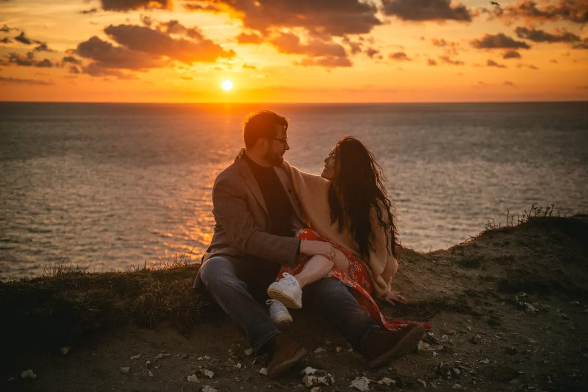 Couple hugging on top of the Etretat cliffs Couple hugging with the Etretat cliffs in the background before their elopement in Normandy