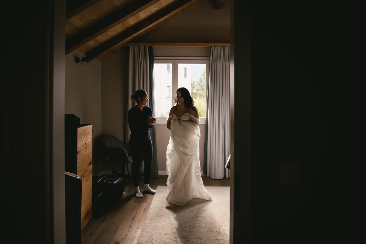 Couple on their elopement day in the Interlaken region of Switzerland - bride putting her dress on