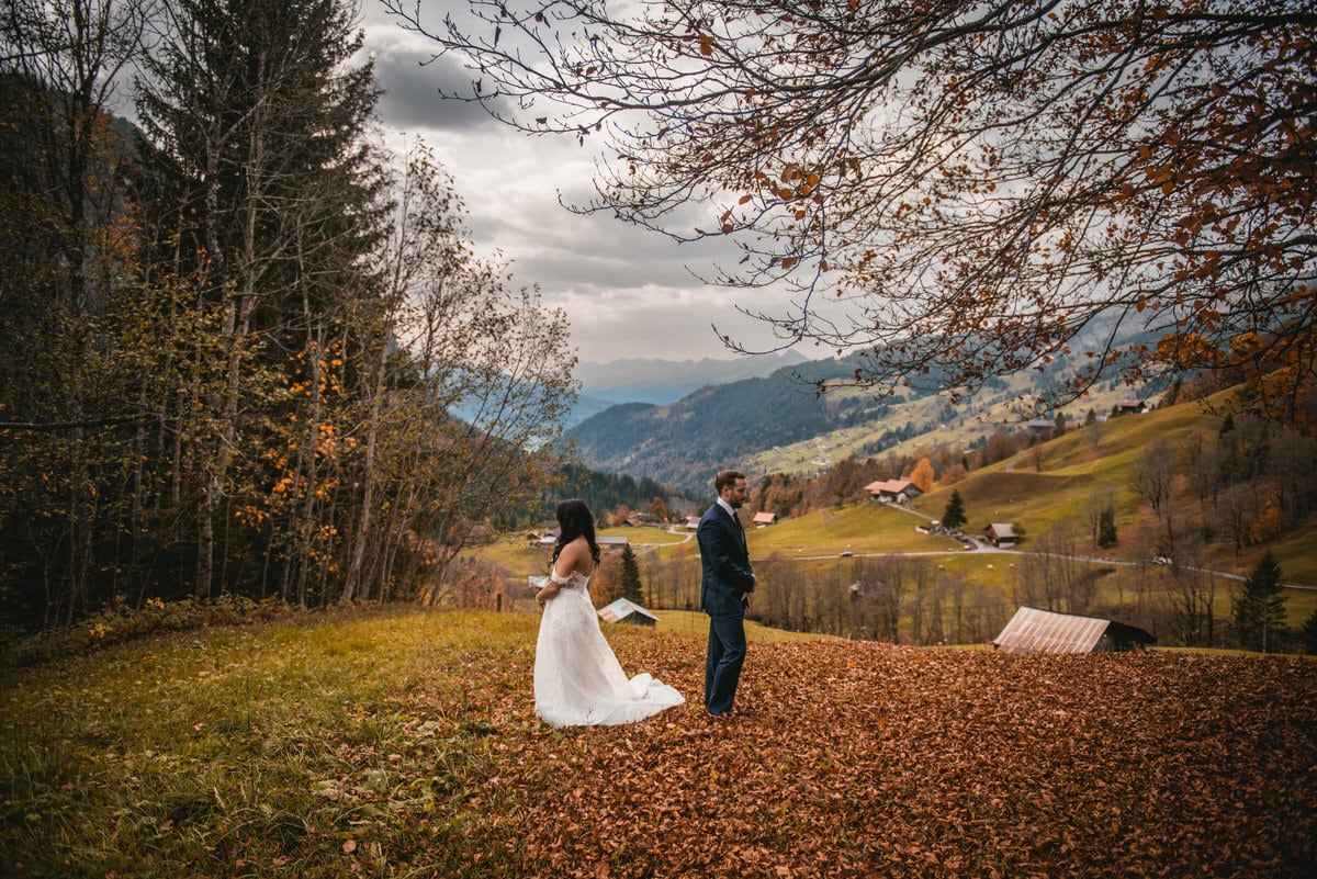 Couple on their elopement day in the Interlaken region of Switzerland - first look under a fall tree