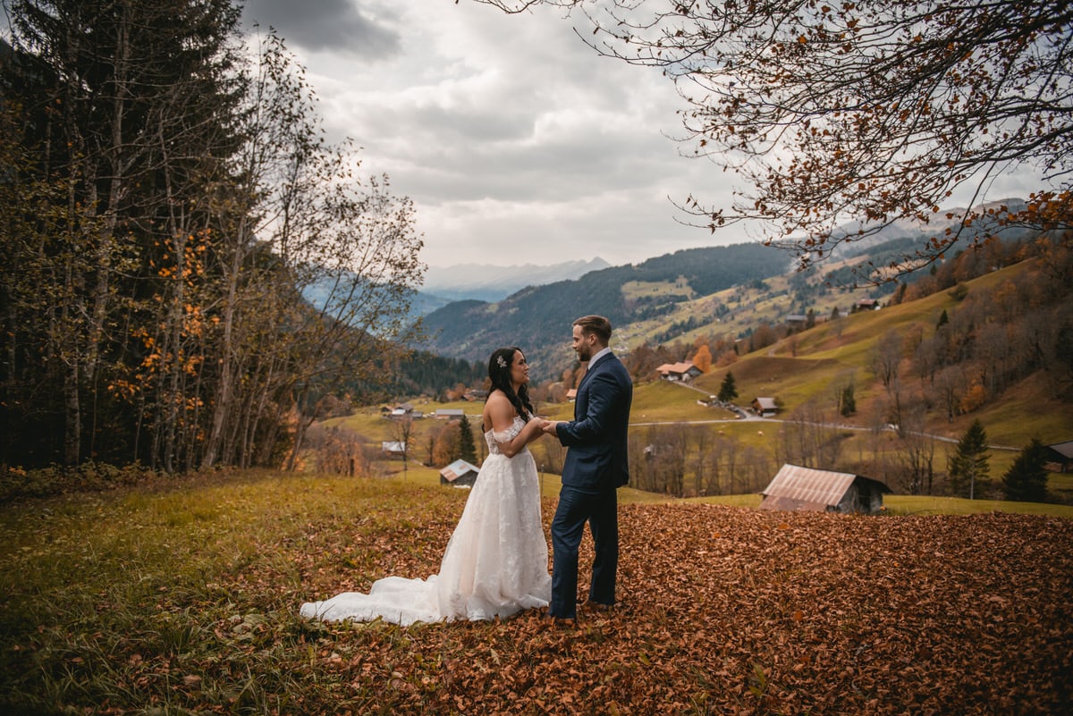 Couple on their elopement day in the Interlaken region of Switzerland - first look under a fall tree