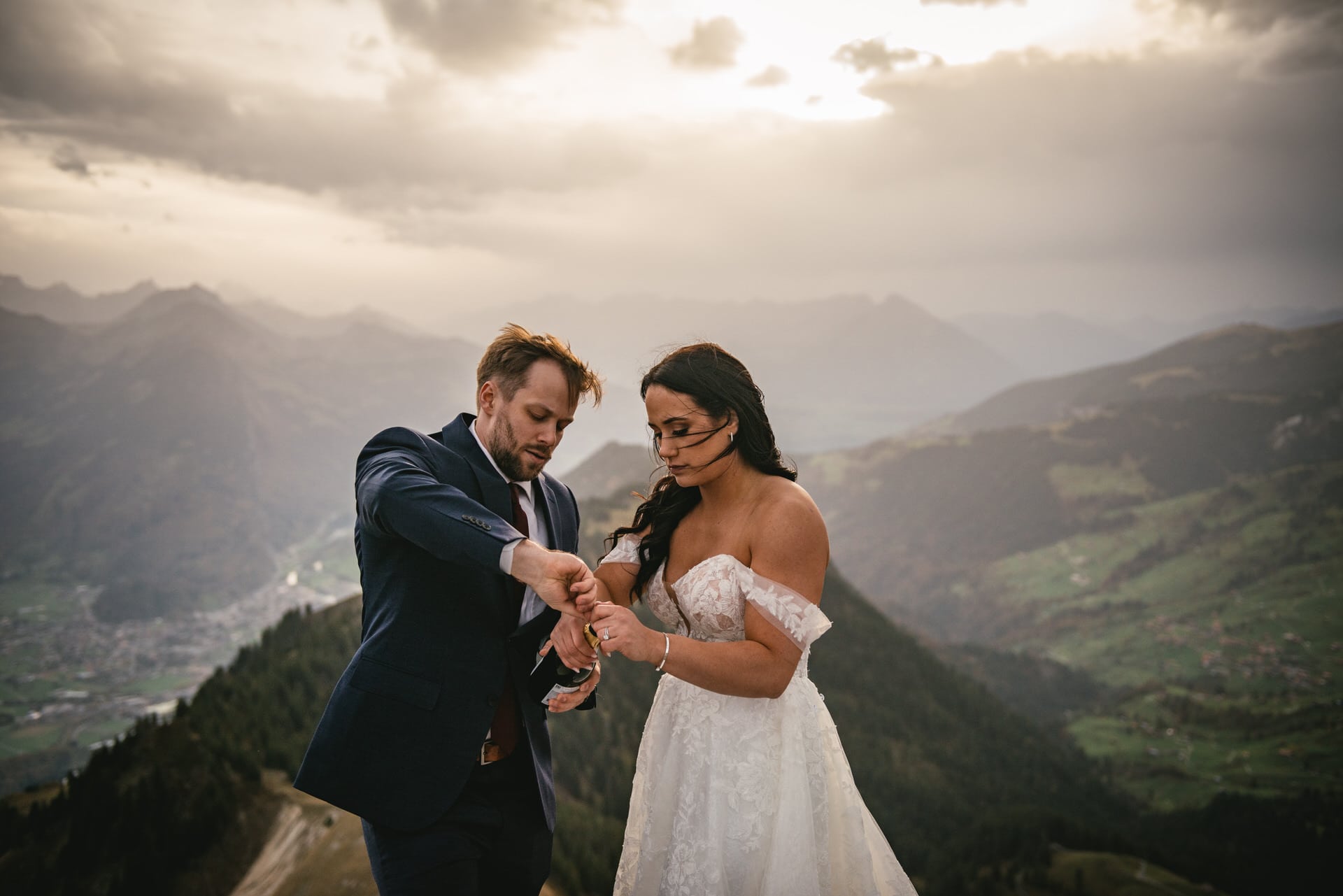 Couple on their elopement day in the Interlaken region of Switzerland - popping champagne
