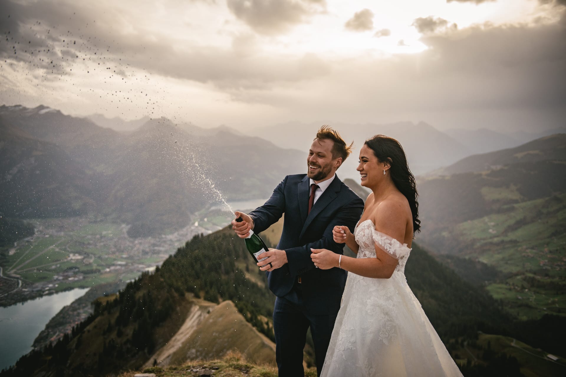 Couple on their elopement day in the Interlaken region of Switzerland - popping champagne