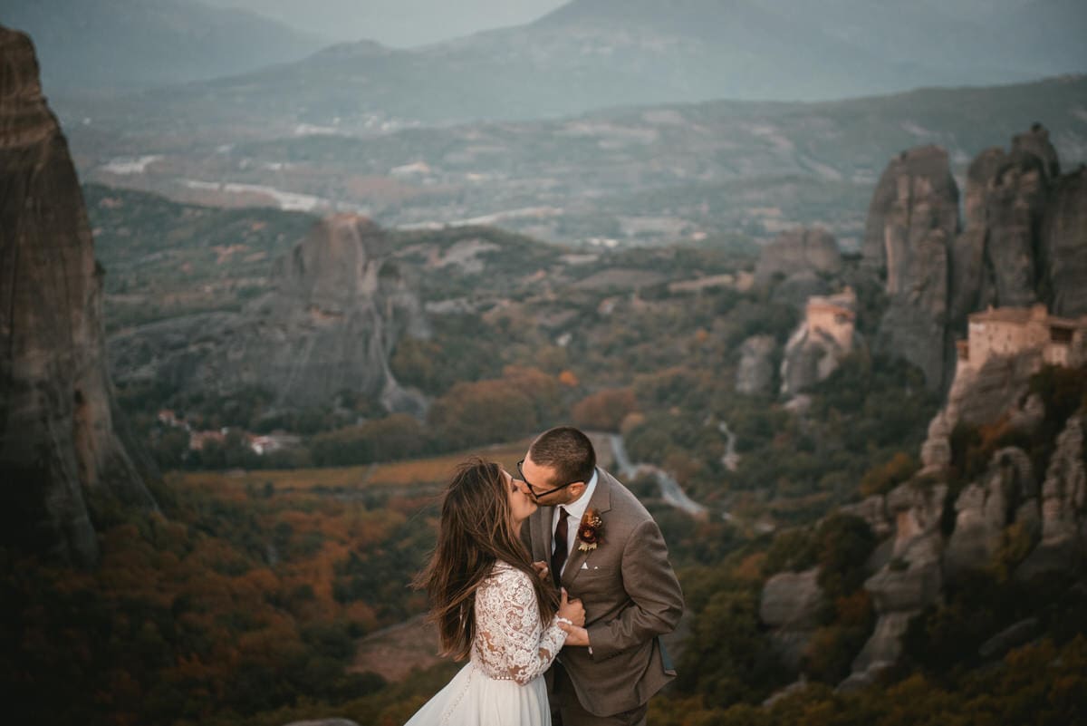 Couple kissing with the Meteora on their day after photoshoot in the Meteora in Greece