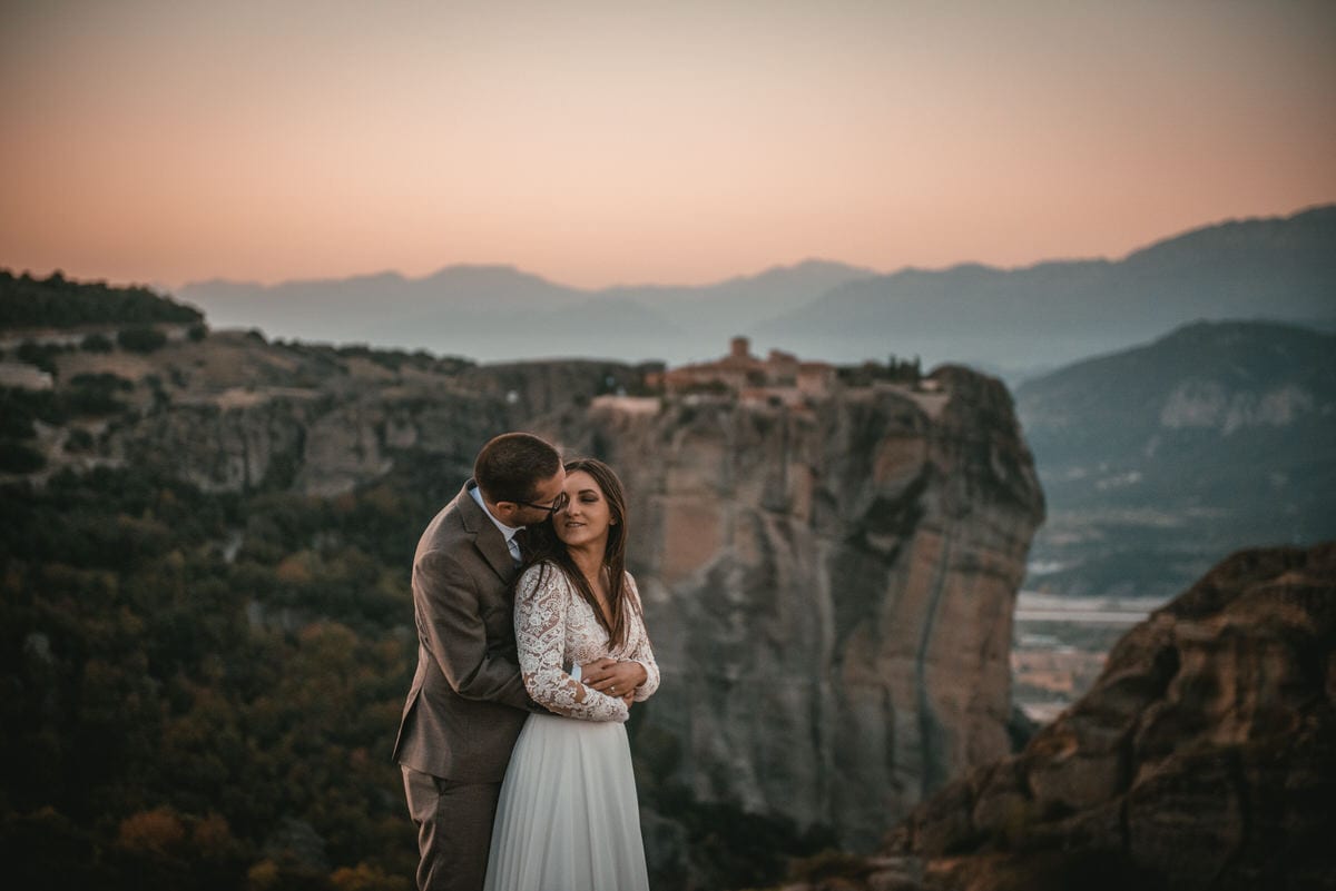 Couple posing with the monasteries on their day after photoshoot in the Meteora in Greece