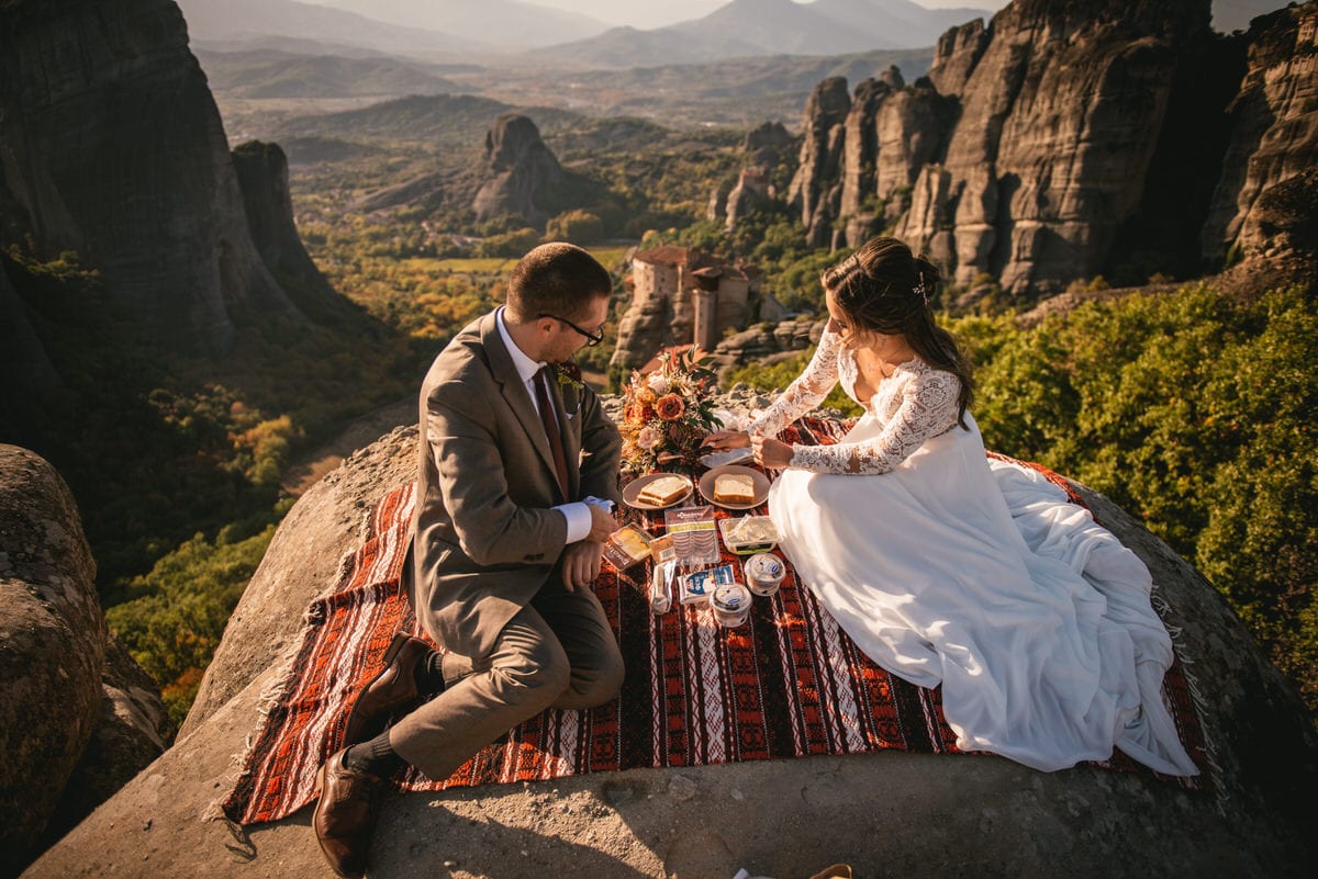 Bride and groom eating a picnic on an elopement day in the Meteora