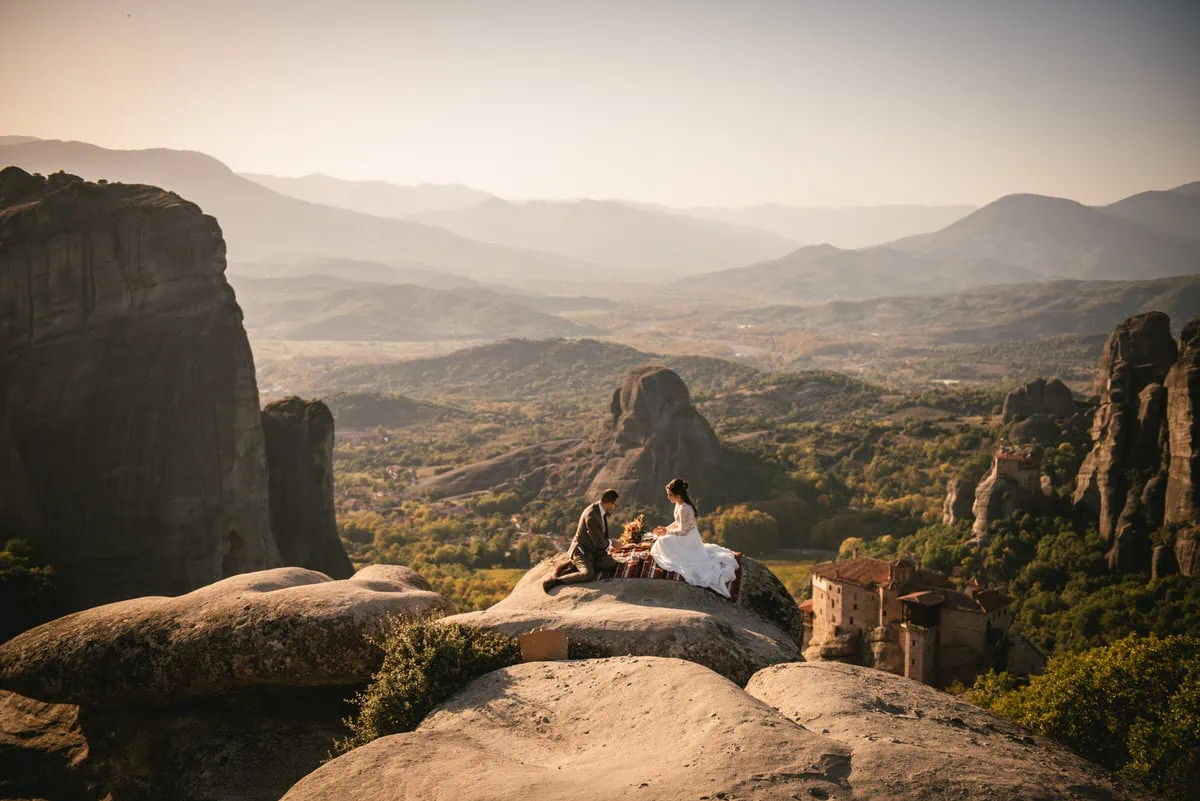 Bride and groom eating a picnic on an elopement day in the Meteora