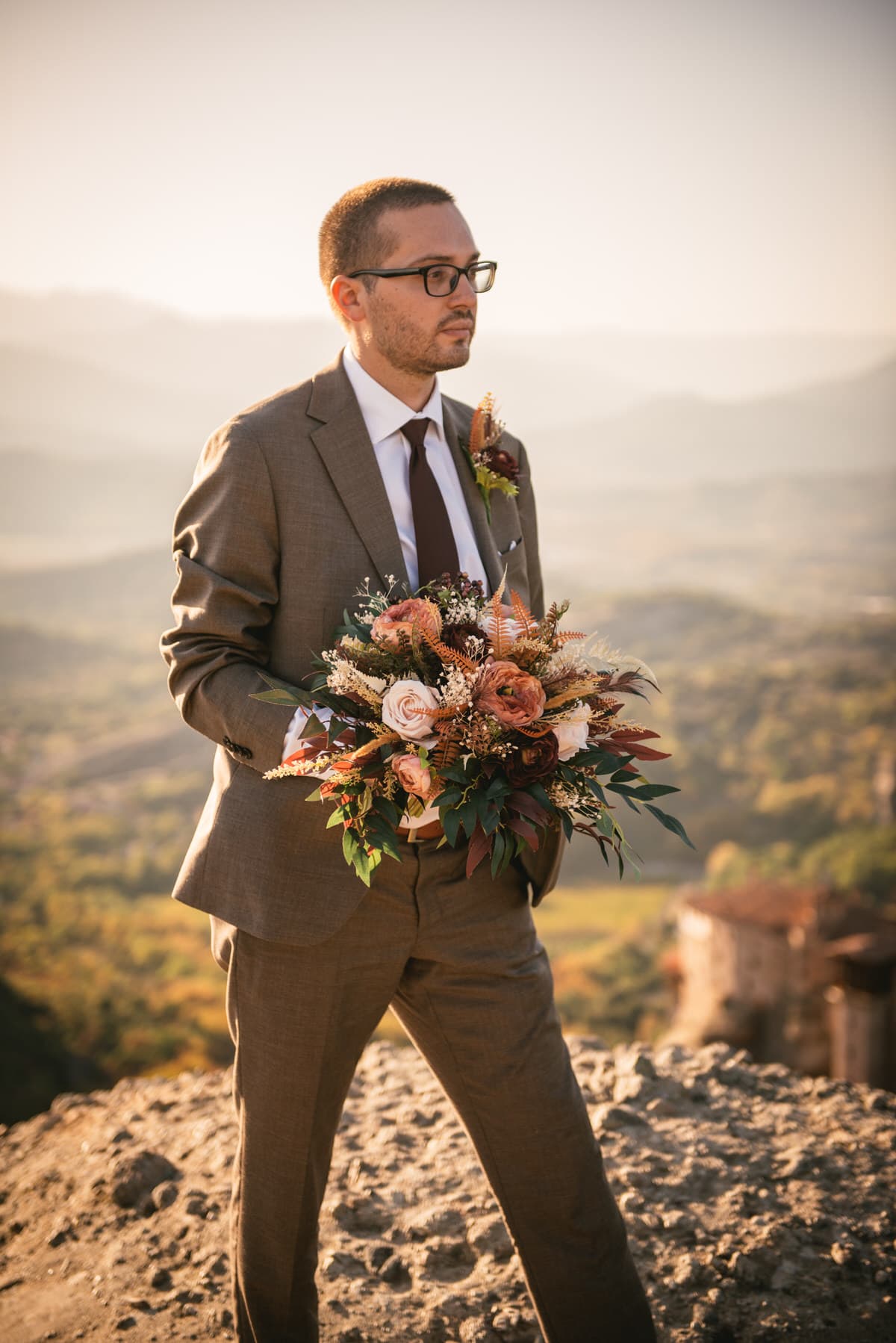Groom holding the flowers on an elopement day in the Meteora