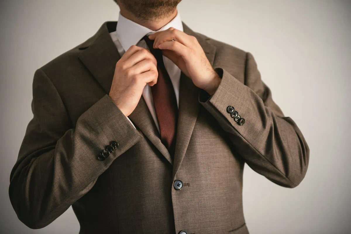 Groom putting his tie on on an elopement day in the Meteora