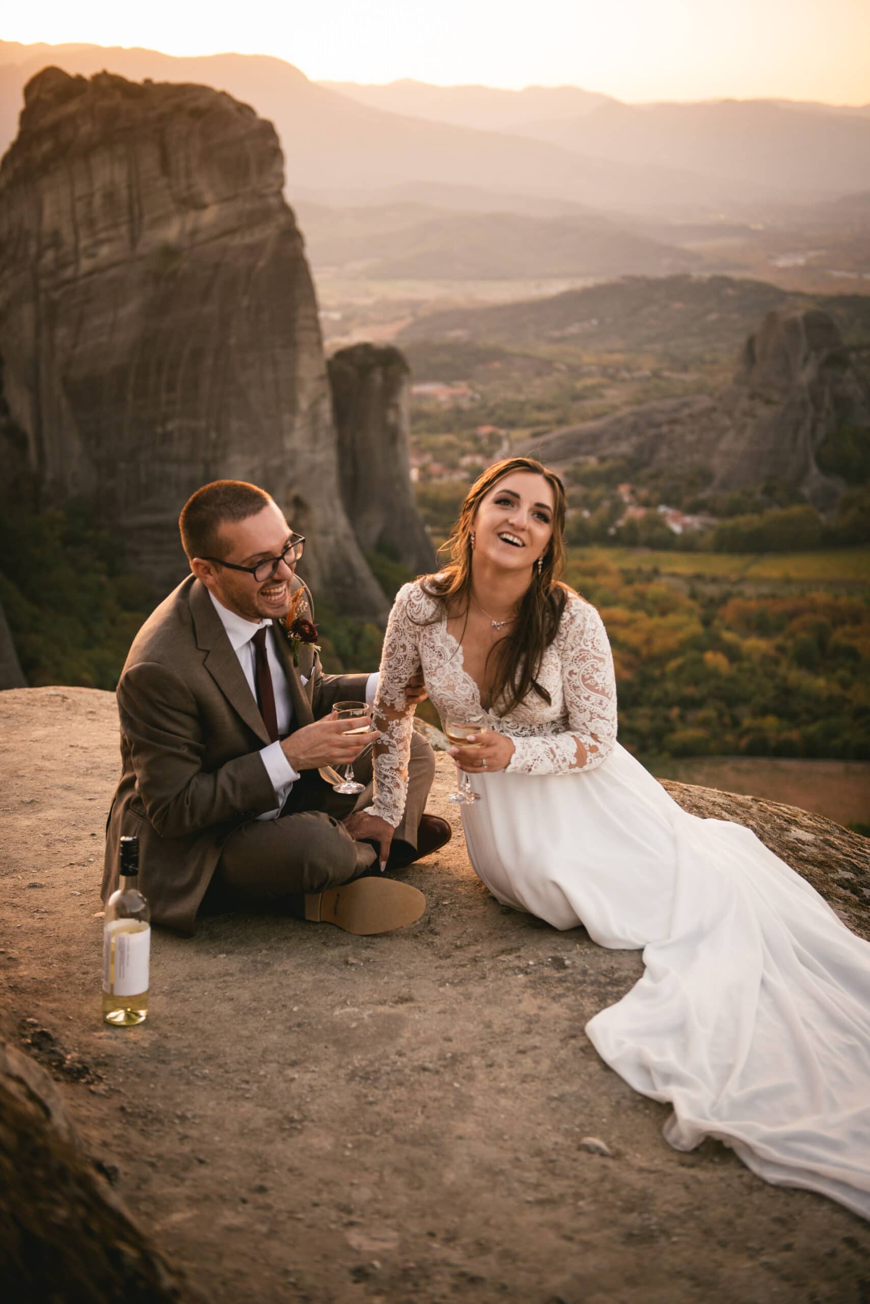 Couple drinking champagne on a rock on their Meteora wedding elopement