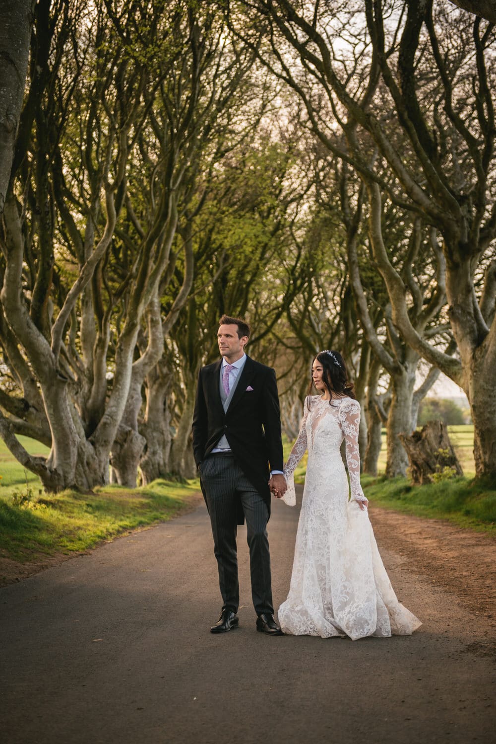 Dreamy shot of the couple walking along a picturesque pathway amidst lush greenery during their Northern Ireland elopement.