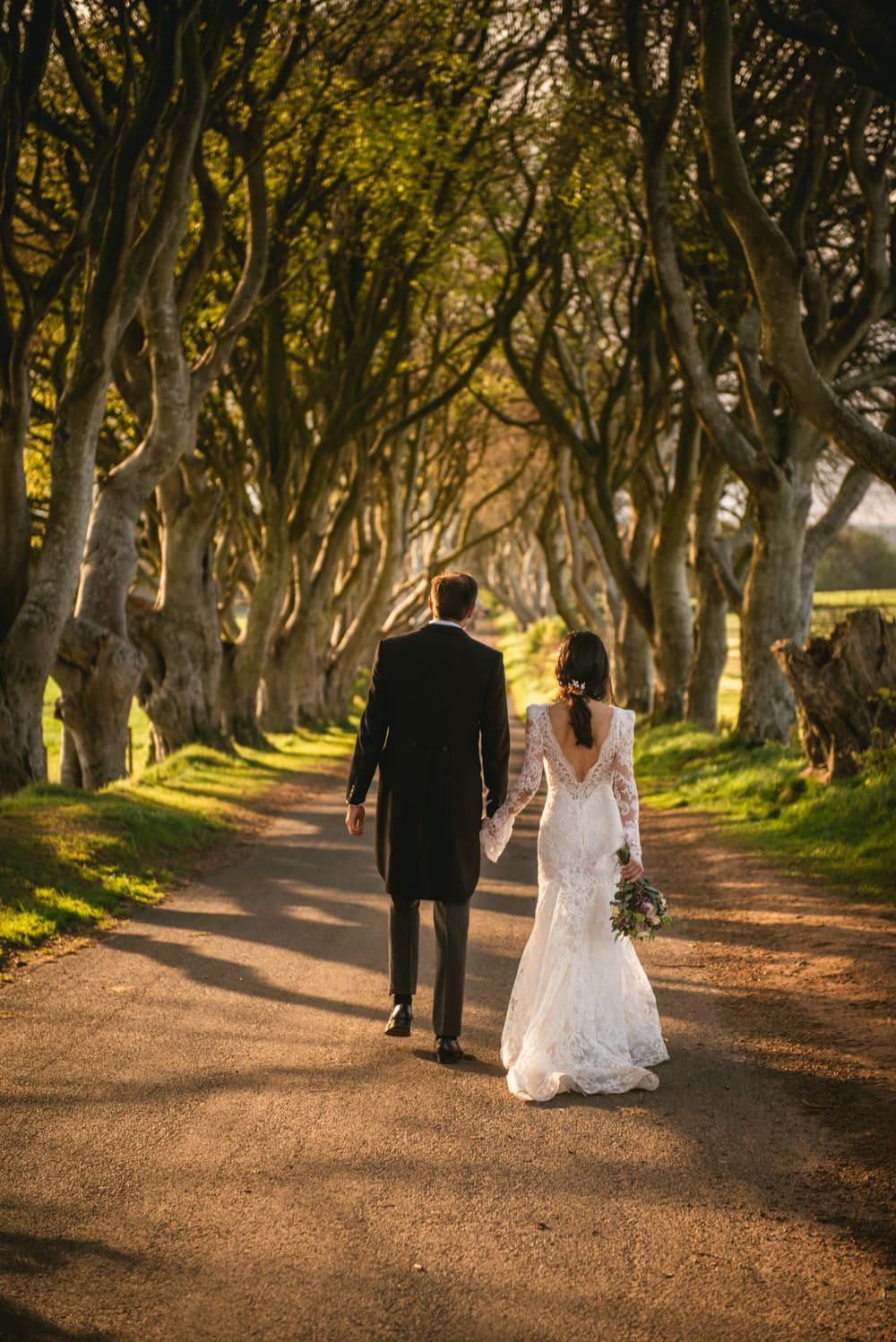 The couple sharing a private moment amidst lush foliage during their Northern Ireland elopement.