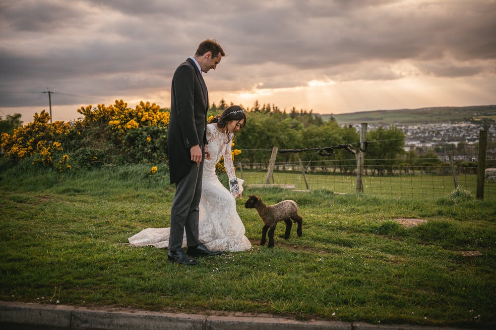 A romantic shot of the couple wrapped in a warm embrace as the sun sets over the Northern Ireland landscape during their elopement.