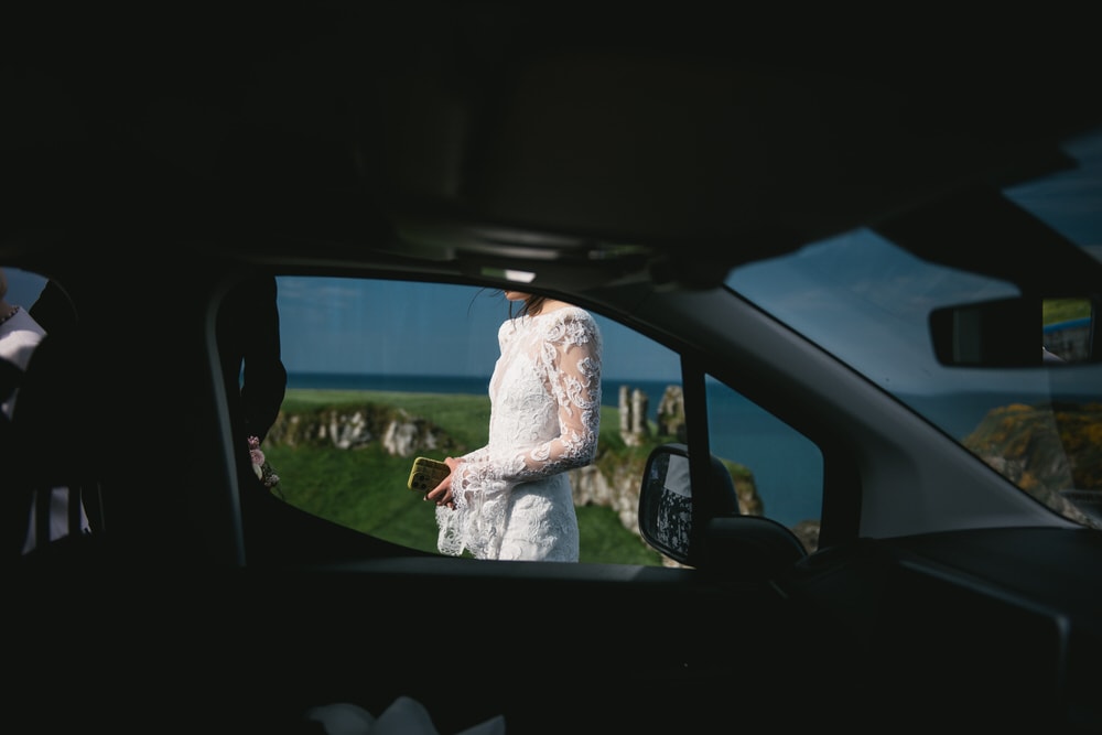 The bride's stunning lace wedding dress in harmony with the enchanting forest setting during her Northern Ireland elopement.