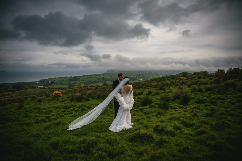 Whimsical shot of the bride's flowing gown billowing in the wind during their Northern Ireland elopement.