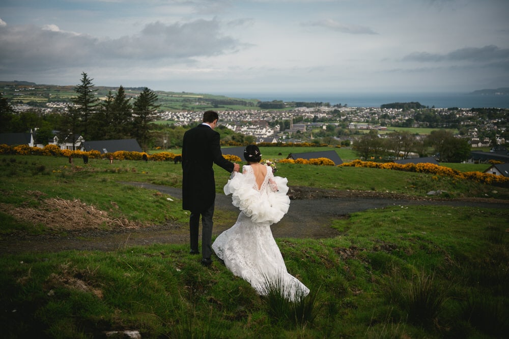 The couple standing on a hilltop, with the rolling hills of Northern Ireland as their backdrop during their elopement.