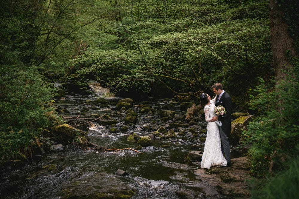 The couple framed by a natural archway of trees during their Northern Ireland elopement.