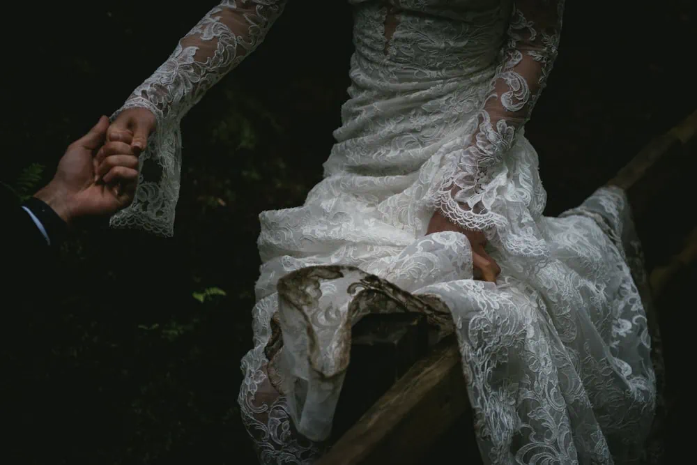 Close-up shot of the couple's intertwined hands with wedding rings during their Northern Ireland elopement.