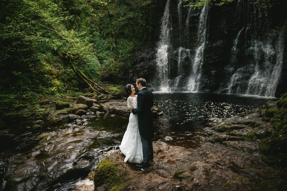 Mesmerizing view of a cascading waterfall in the heart of the forest during their Northern Ireland elopement.